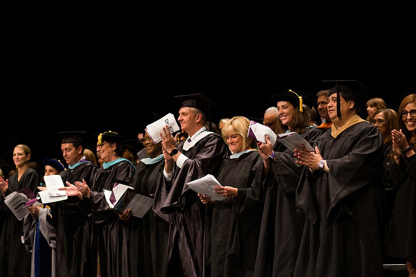 Faculty and distinguished guests clap for the performers.