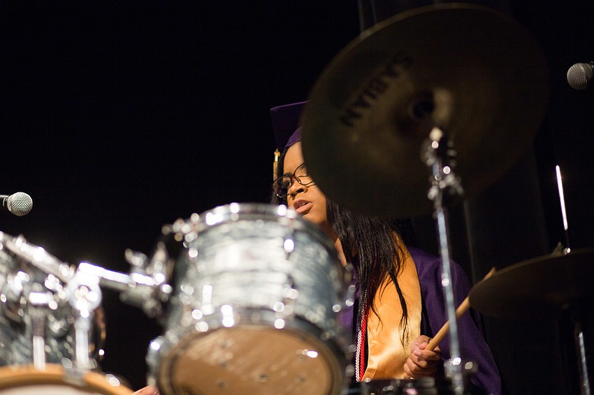 A student drums during the performance of 