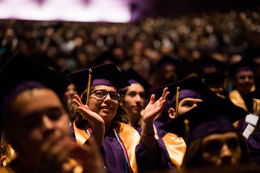 A graduate claps along to the song.