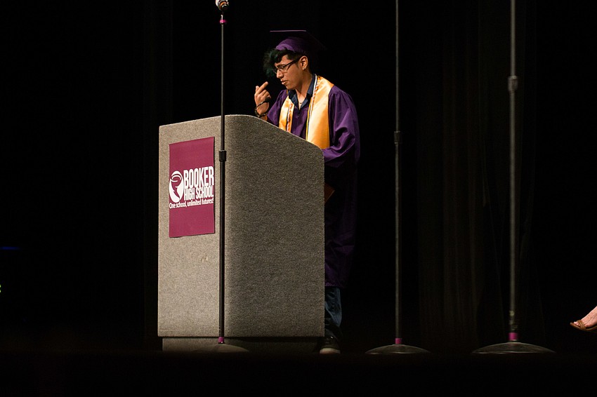 Franco Ruiz points to his hair during his commencement speech and says 