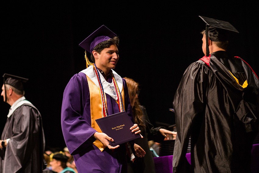 A graduate walks the stage after grabbing his diploma.
