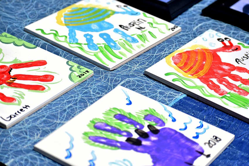 The graduates made tiles with their handprints for their parents.