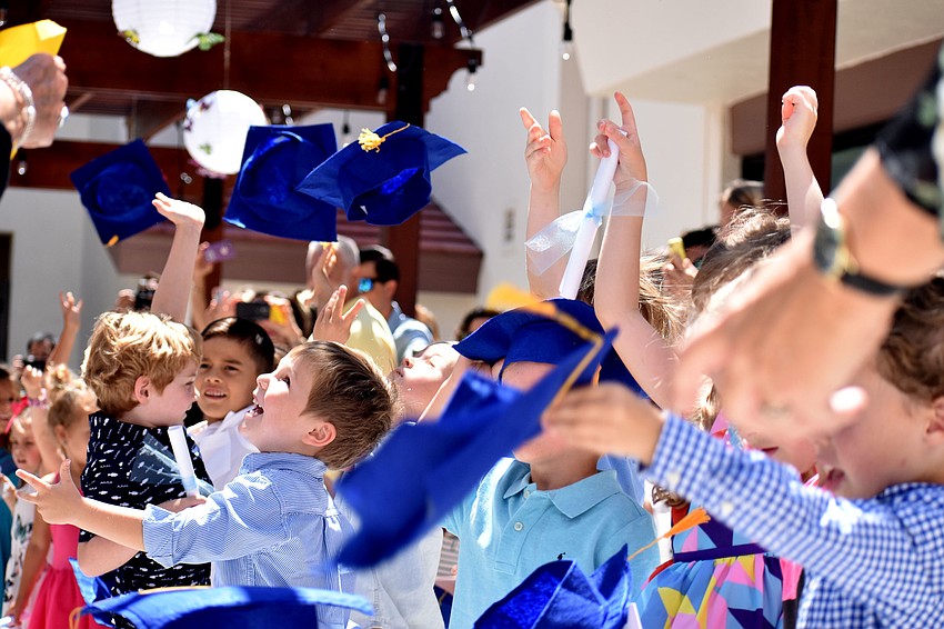The graduates are all smiles as they toss their caps in the hair in celebration of their graduation.