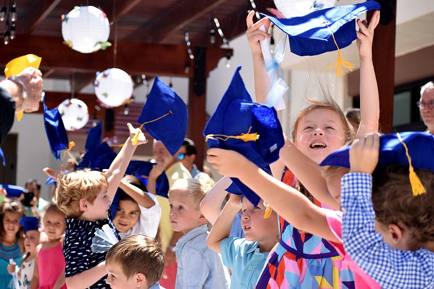 The graduates are all smiles as they toss their caps in the hair in celebration of their graduation.