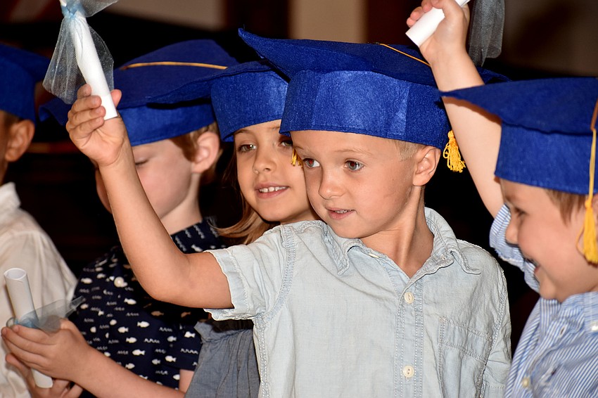 Graduates smile at their parents as they receive their diplomas.
