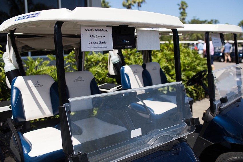 Golf carts lined up, ready for the start of the golf tournament.