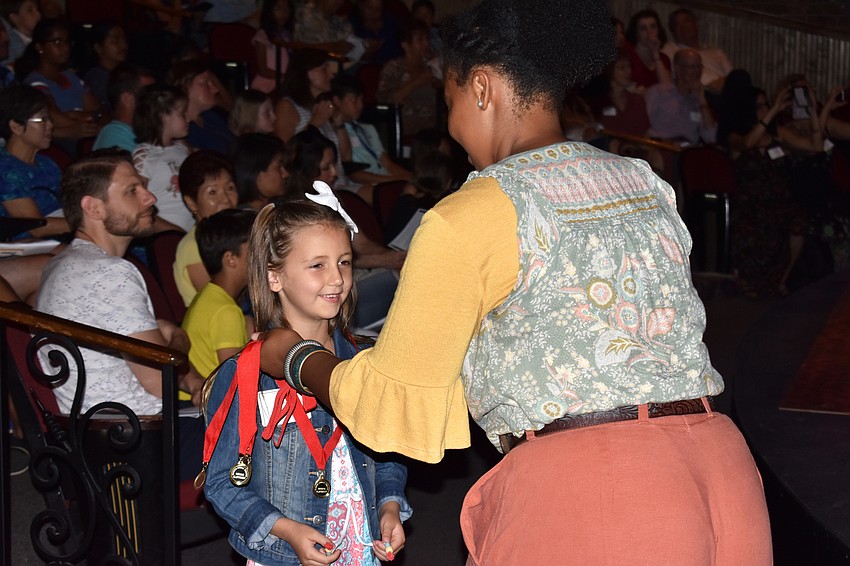 One of the four winning playwrights behind the play “Nibbles,” Lily Light, is awarded her medal.