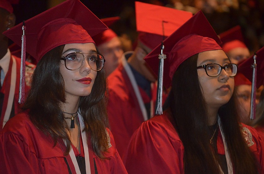 Nasreen Abdullah and Amy Aburto watch a senior recap video shown at graduation.