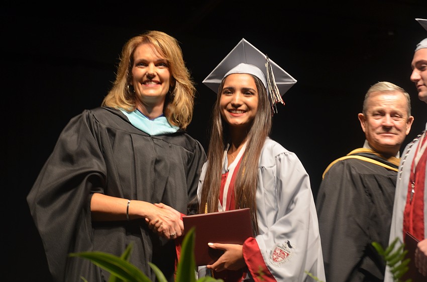 Principal Sharon Scarbrough presents Andrea Aguirre with her diploma.