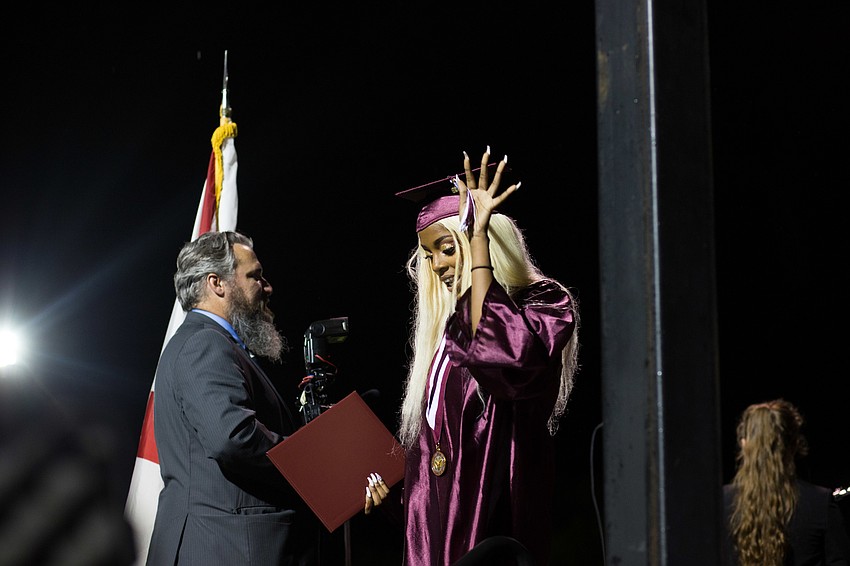 A student flips her tassel as she walks down the stairs.