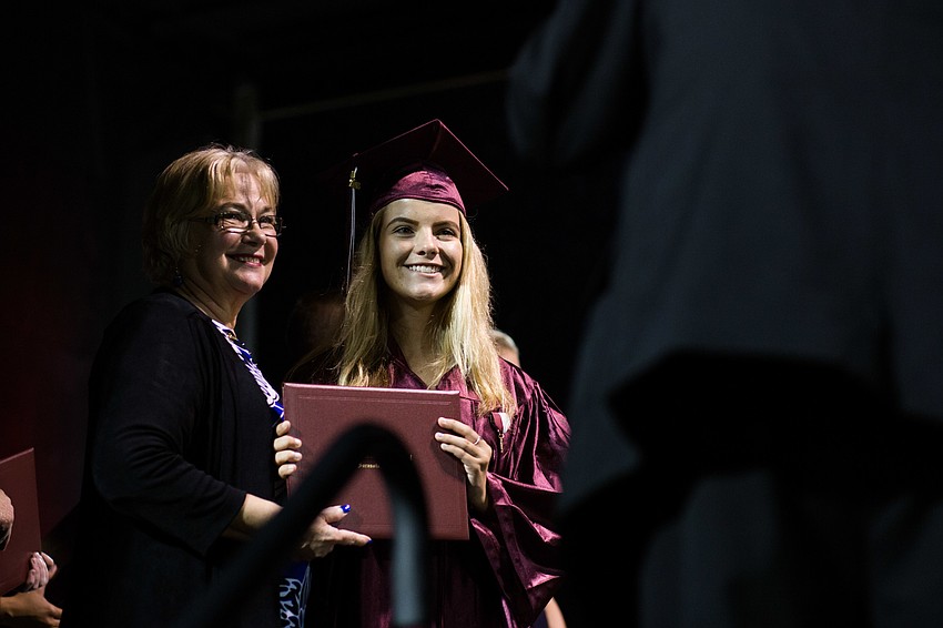 A graduate smiles for a photo after getting her diploma.