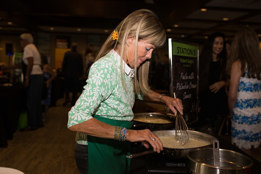 Cheryl Yeats stirs the sauce for Robert Gaglio's dish, pasta with pistachio cream sauce.