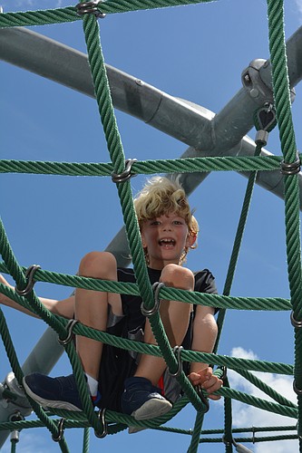 Zalan Guilbert, 8, climbs on a rope structure at the Nathan Benderson Park playground. The playground soon will be covered by a shade structure.