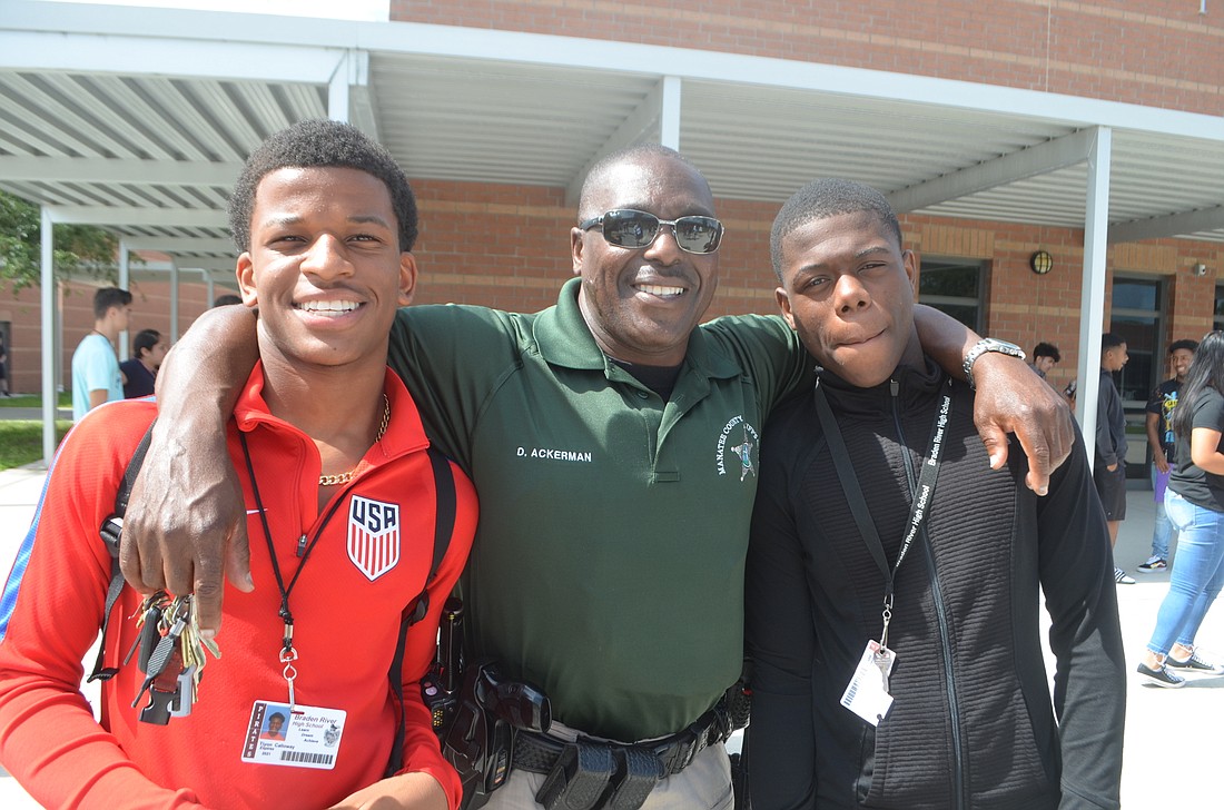Deputy Damon Ackerman, here with Tiyon Calloway and Geland Veillard, ninth-graders, says that most students take a while to warm up with the deputy on campus.