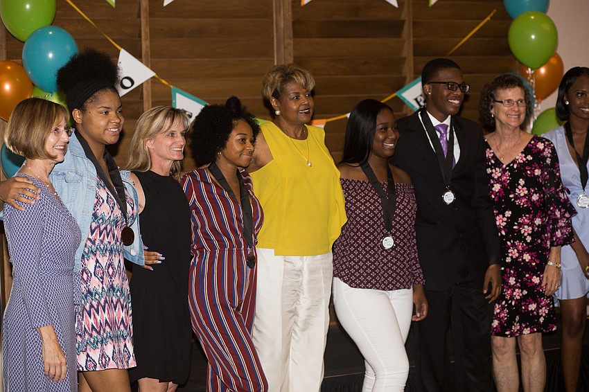 Booker High School graduates and their mentors pose for a photo.