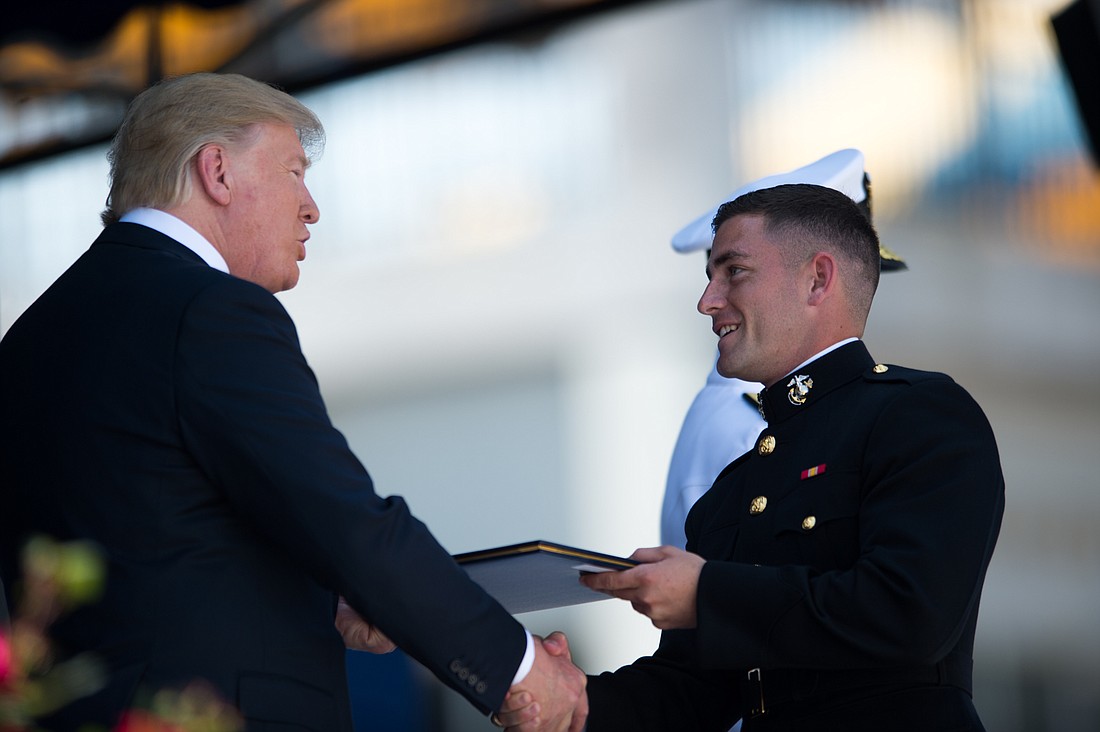 President Donald Trump awards Sam Valley his diploma.