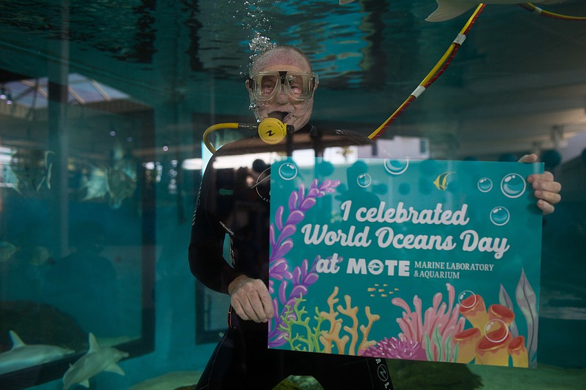 A scuba diver swam in a tank for photo opportunities.