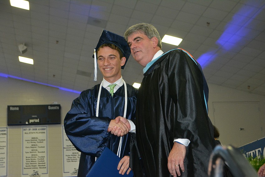 Christopher Eckart gets his diploma and a handshake from Head of School David Mahler.