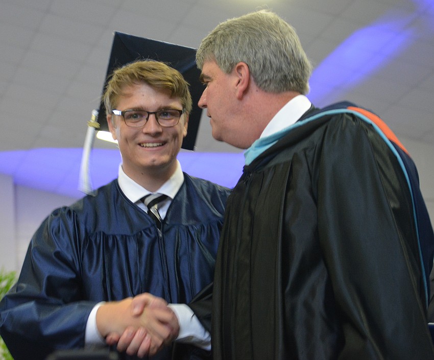 Kevin Bernet is congratulated by Head of School David Mahler.