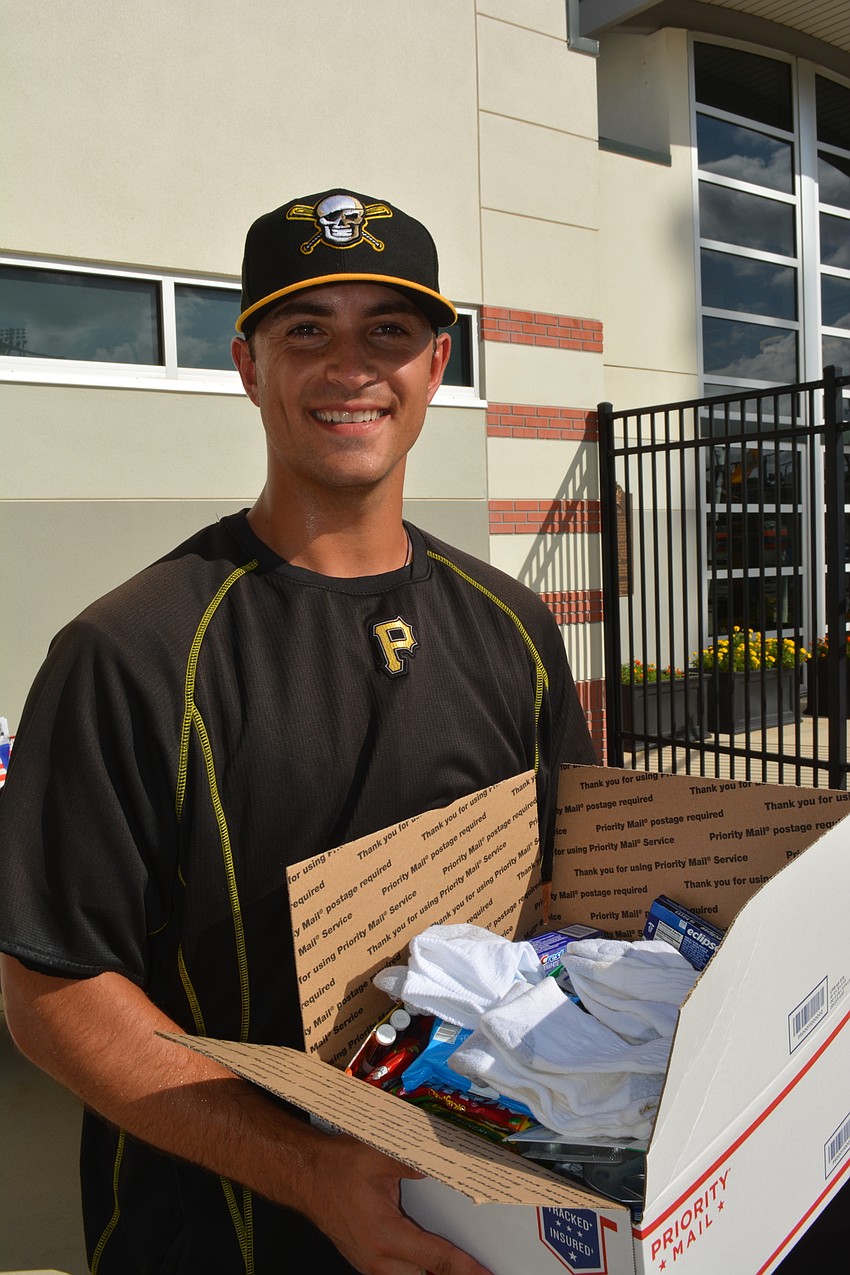 Marauders pitcher Jess Amedee carries a Manatee Operation Troop Support box on Military Appreciation Night June 2 at LECOM Park.