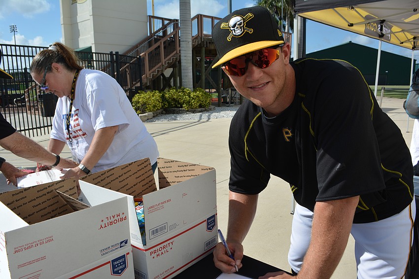 Marauders catcher John Bormann helps pack items for Manatee Operation Troop Support on Military Appreciation Night June 2 at LECOM Park.