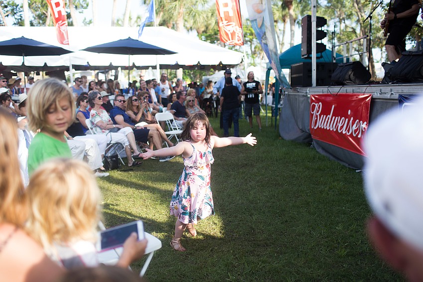 A child runs around in front of the stage while the band played.