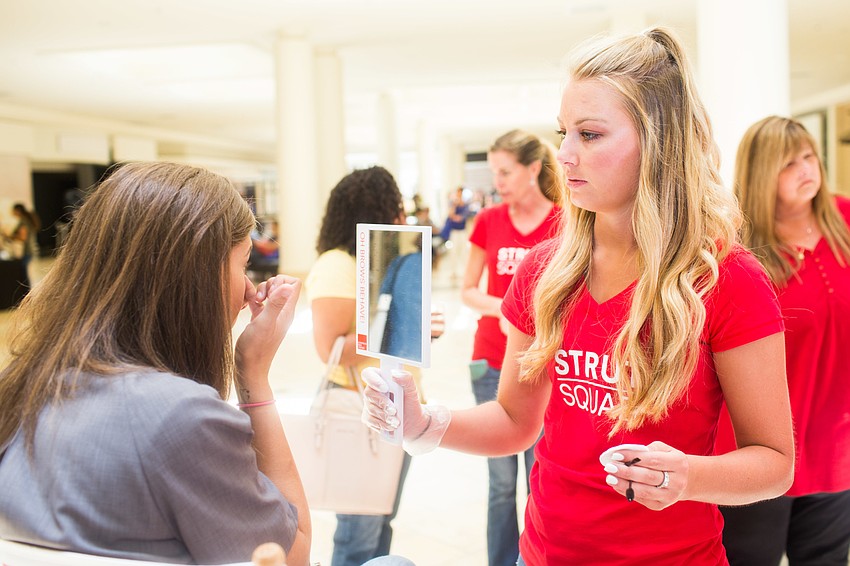 Ashley Schutte from the European Wax Center shows a guest her newly waxed brows.