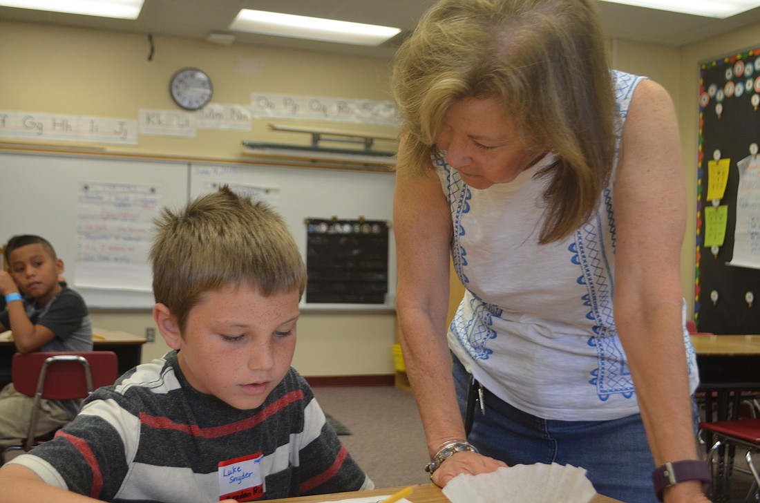 Luke Snyder, a third-grader from Braden River, gets help with his reading from Susan Hagerman on the first day of summer school.