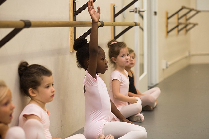 Harper Taylor raises her hand to guess what animal the other student was dancing as.