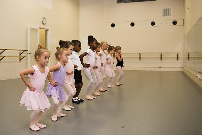 The students lined up to practice their ballet positions in front of the mirror.