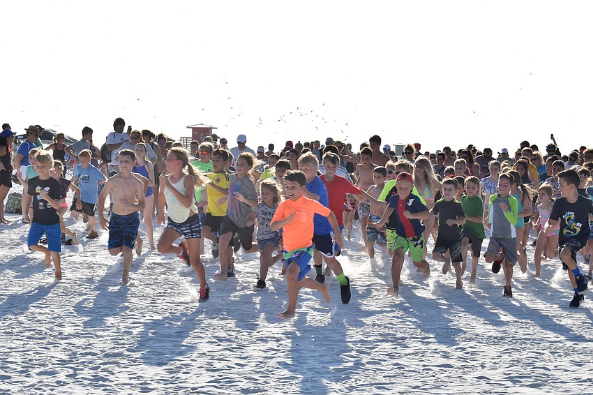 Kids and some parents take off from the start line of the 1-mile run on June 5, 2018, at Siesta Beach.