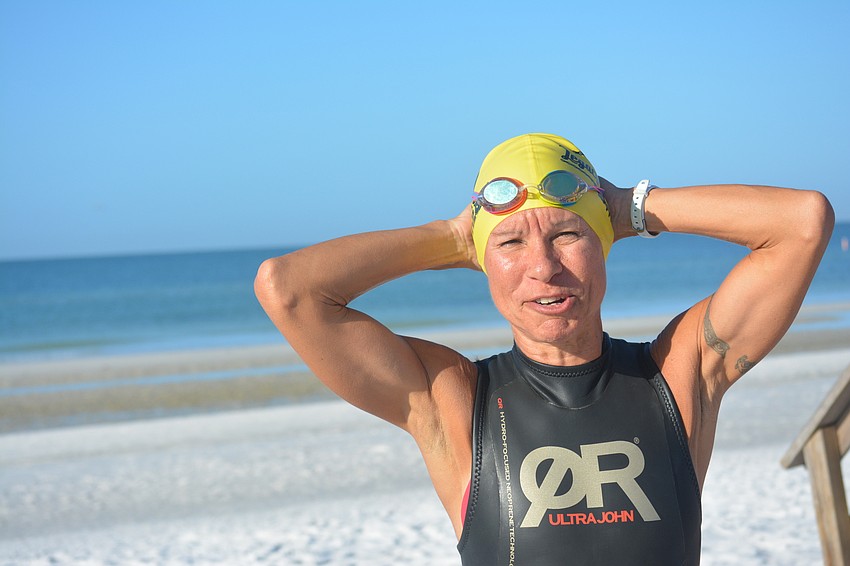 Sarasota triathlete Linda Bayne stretches on Oct. 18 before a swim session on Siesta Beach. Bayne, a “punk rock hippie” who qualified for the 2017 Ironman 70.3 World Championship in Chattanooga, Tenn., loves pushing her body to its limits.