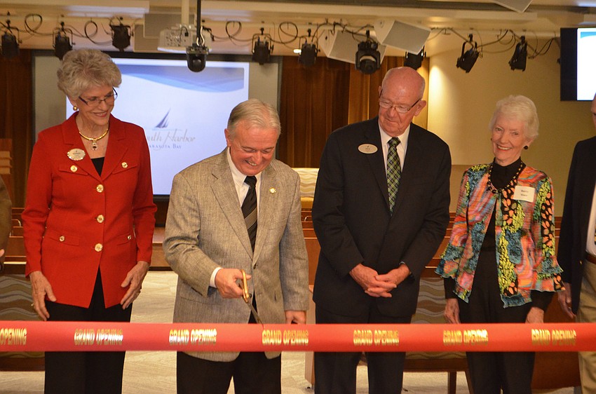 President and CEO of Plymouth Harbor Harry Hobson smiles as he makes the first cut into the ribbon at Pilgrim Hall’s reopening.