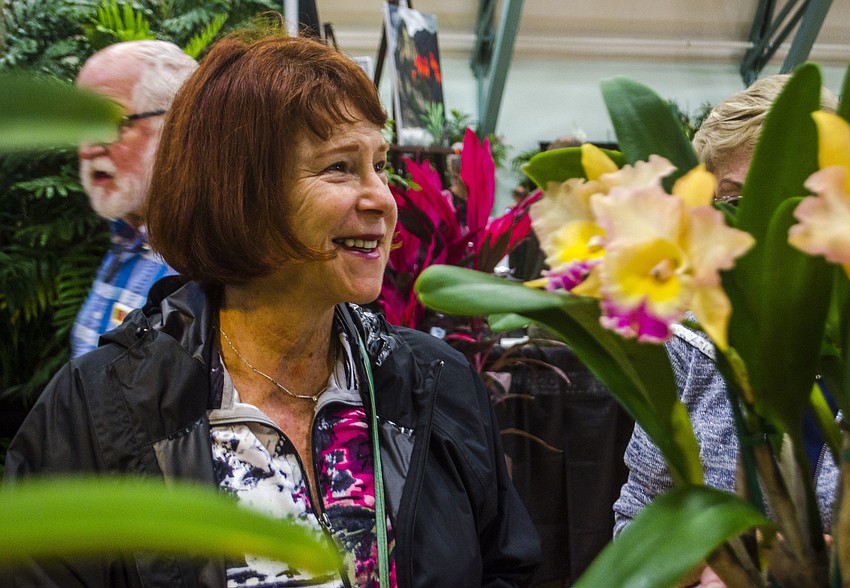 Ellen Kaiden selects an orchid to purchase from Patricia and Paul Phelps. A water color artist, Kaiden was selecting a orchid for her next painting.