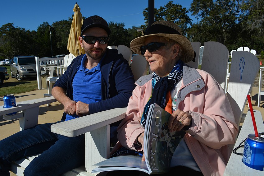 Michael Kirton chats with his grandmother, Marion Walker, who reads the rules of polo during her first match.