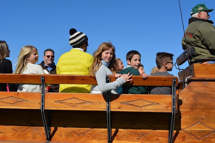 Matilda Llosa, center, and her cousin Miguel Mendonsca, in green, ride a wagon pulled by a team of clydesdales.