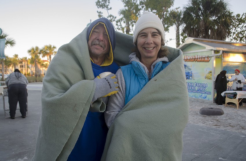 Sam Monroe and Karen Foust try to stay warm before the race.