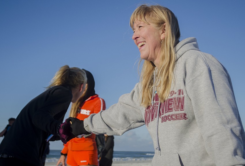 Stacey Monroe congratulates runners as they finish the race.