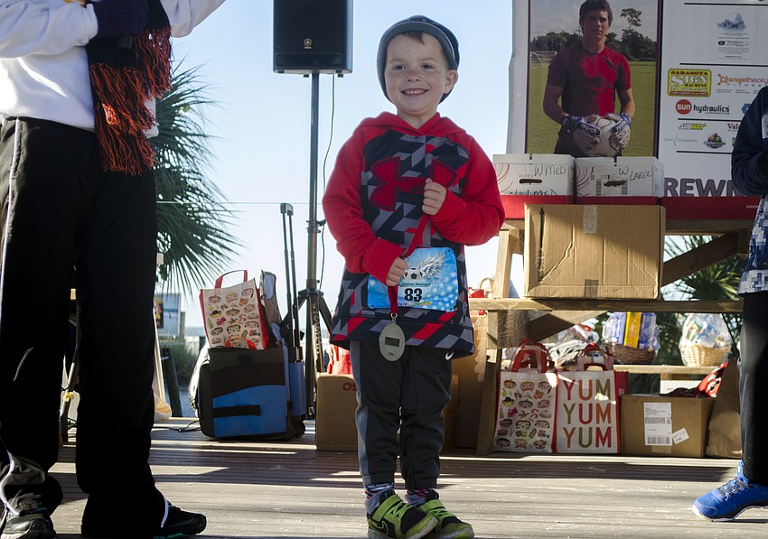 Mason Howard poses with his medal for finishing among the top three in his age group.