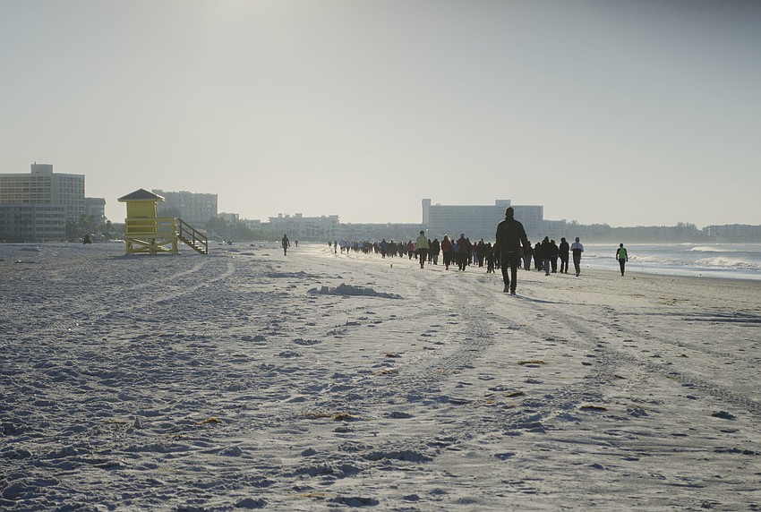 Runners in the Andrew Monroe 5K make their way down Siesta Key Beach.
