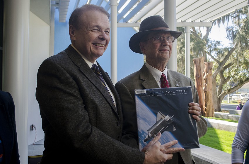 Ringling College of Art and Design President Larry Thompson poses with Bob Kimbrough as the last books makes it way to the end of the assembly line. The old library was named after Kimbrough'    s father, Vernon Kimbrough.