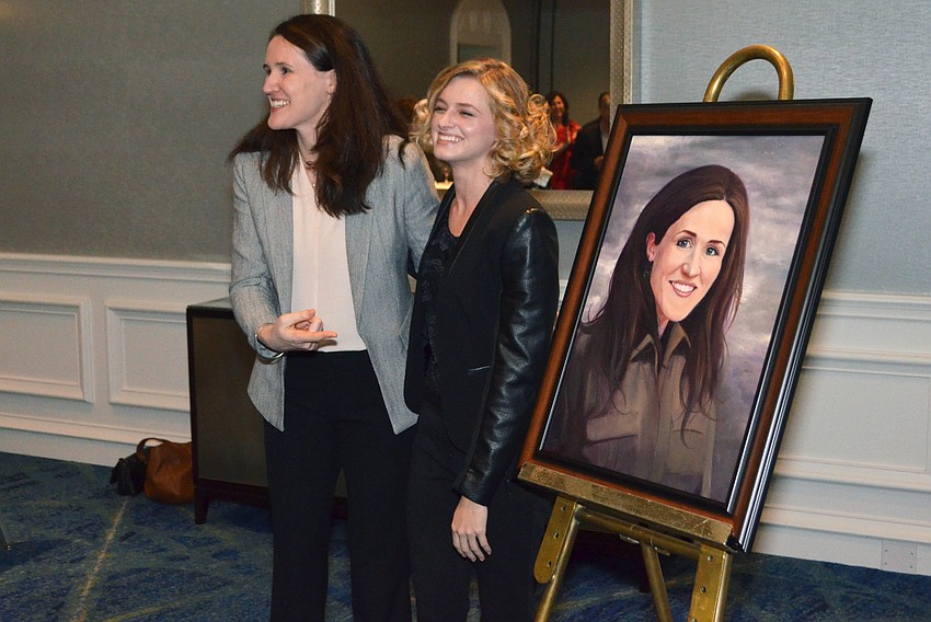 Liz Murray congratulates Saige Libertore after her portrait is unveiled.