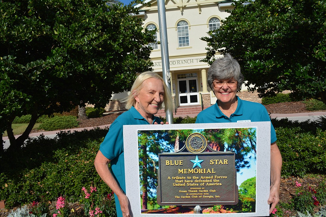 Gardeners Out East President Carolyn Lowry-Nation and Blue Star Memorial project manager  and club member Karen Eckert stand with a rendering of the marker in its proposed location in front of Lakewood Ranch Town Hall.