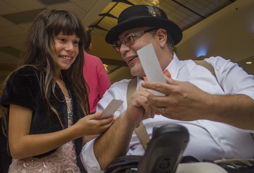 Tom and Faith Class look at their photo booth photos.