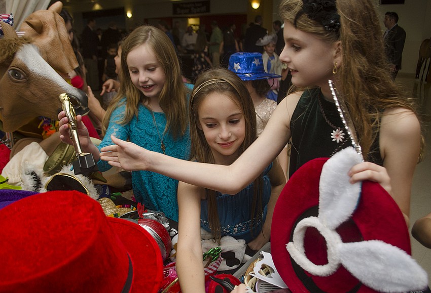Alaina Reboul, Ashley Olah and Eve Hare choose props to take with inside the photo booth.