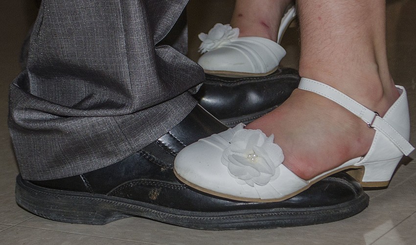 Jasmine Antico stands on her father’s shoes while they dance at St. Mary Academy and St. Martha Catholic School’s father daughter dance.