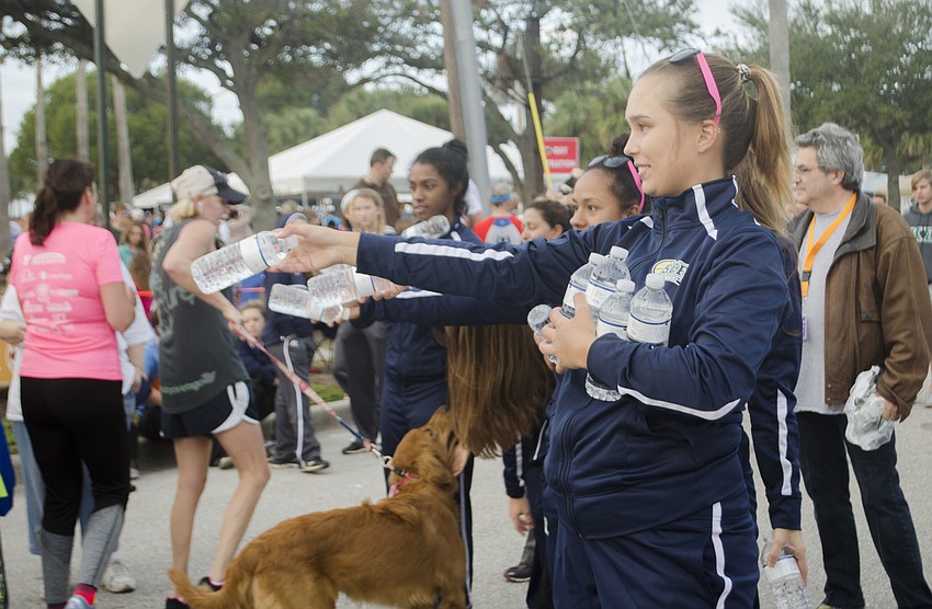 Maria Zubkova passes out water at the finish line of the 14th annual Ringling Bridge Run.