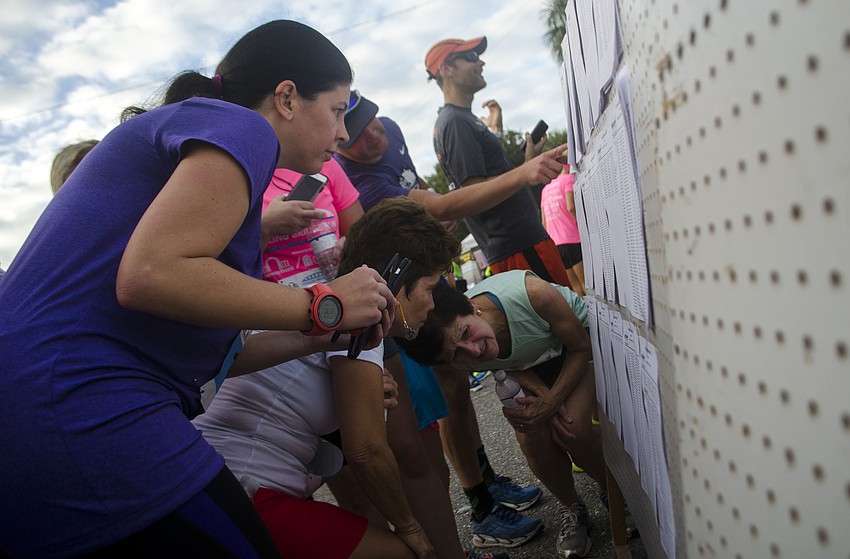 Runners check their times after finishing the 14th annual Ringling Bridge Run.