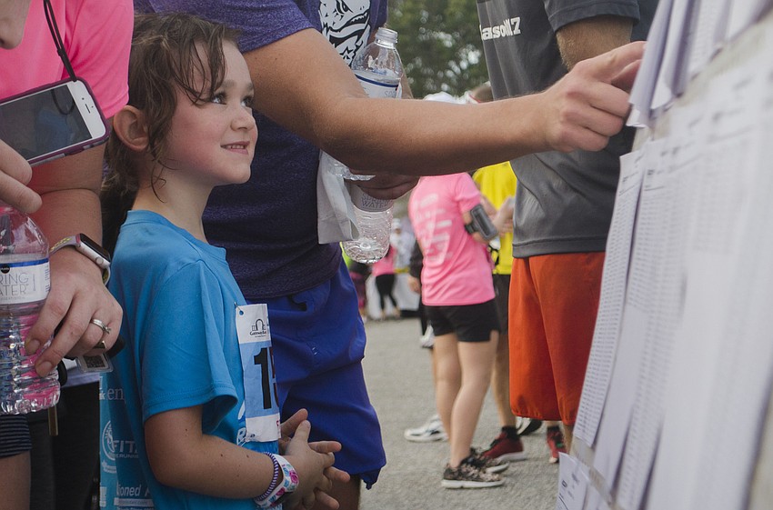 Carrie Sarkissian, 6, smiles while checking her race time.