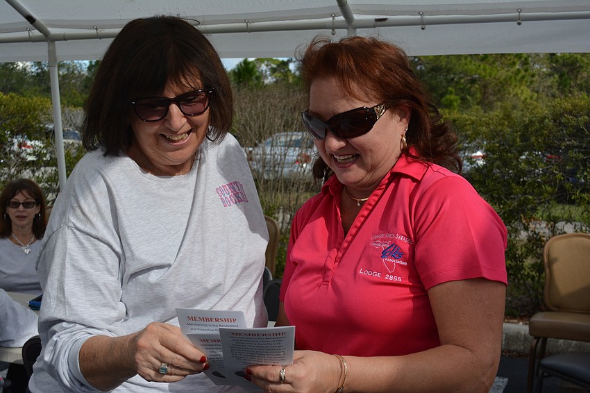Sarasota'  s Kathy Corona looks over a membership application with Elks Leading Knight Tonya Ditty.